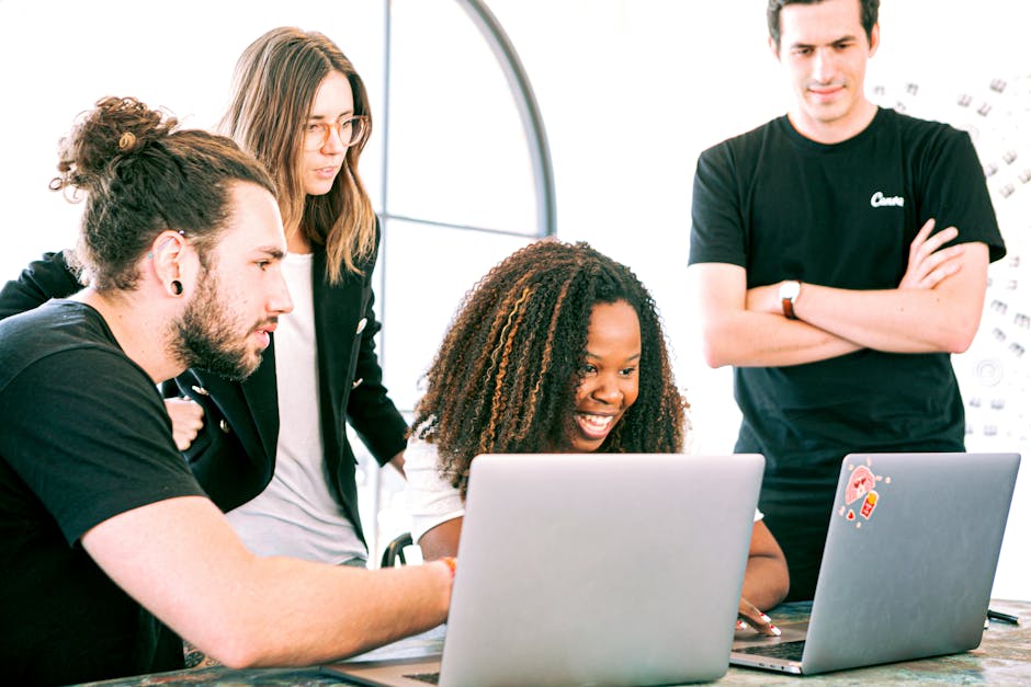A diverse group of young professionals collaborating enthusiastically in a bright, modern workspace